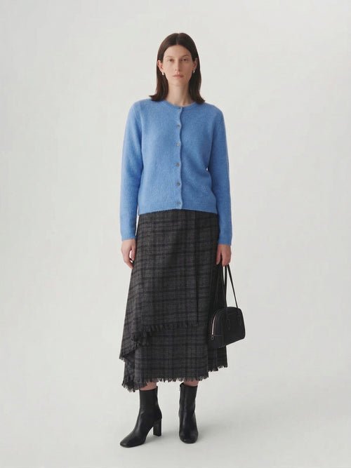 Load image 1 in gallery view. Silk-Cashmere Cardigan in soft blue hue worn with a plaid skirt, showcasing versatility for layered outfits.