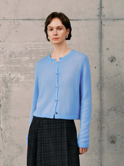 Load image 1 in gallery view. Silk-Cashmere Cardigan in soft blue hue worn with a plaid skirt, showcasing versatility for layered outfits.