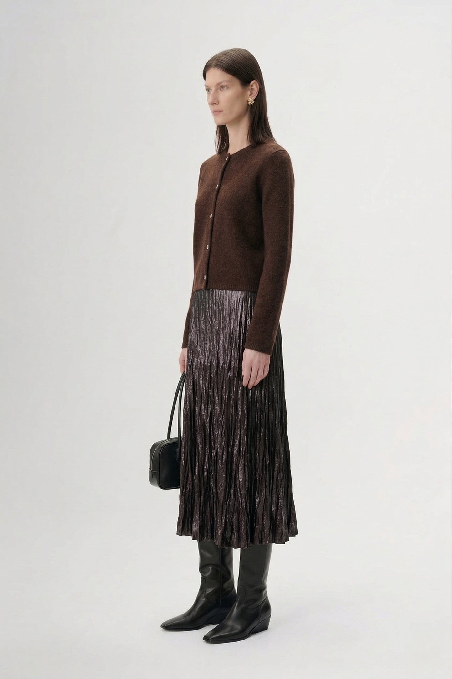 Silk-Cashmere Cardigan styled with a pleated metallic skirt and knee-high boots in a modern interior.