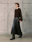 Silk-Cashmere Cardigan styled with a pleated metallic skirt and knee-high boots in a modern interior.