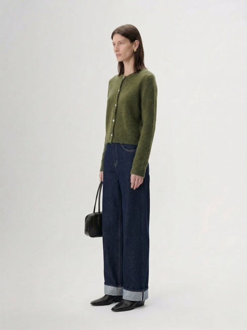Load image 1 in gallery view. Silk-Cashmere Cardigan displayed over wide-leg trousers on a model against a minimalist concrete background.