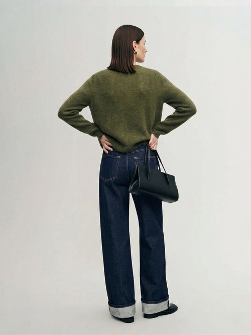 Load image 1 in gallery view. Silk-Cashmere Cardigan displayed over wide-leg trousers on a model against a minimalist concrete background.