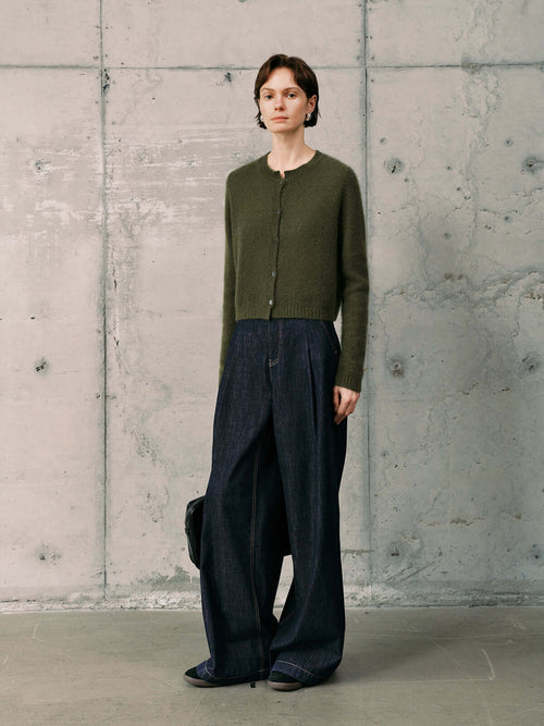 Load image 1 in gallery view. Silk-Cashmere Cardigan displayed over wide-leg trousers on a model against a minimalist concrete background.