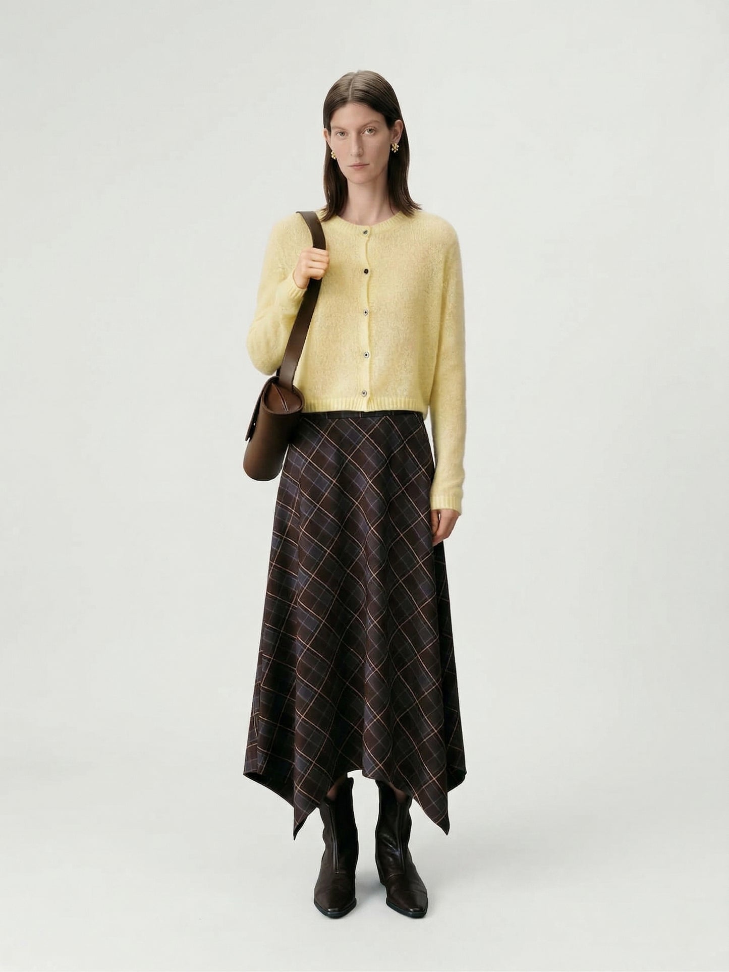 Silk-Cashmere Cardigan styled with a plaid skirt, showcasing a soft yellow hue and lightweight design.