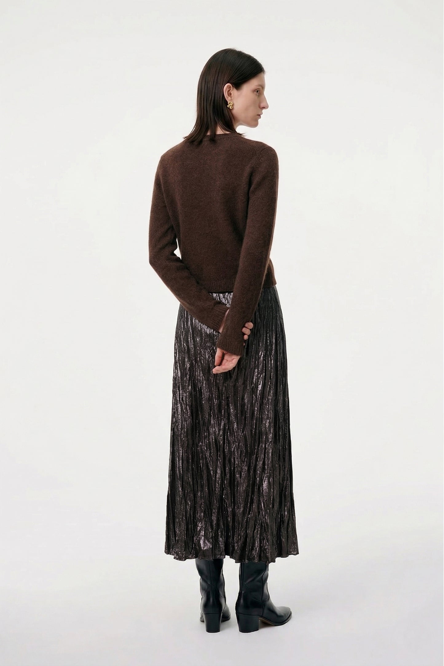 Silk-Cashmere Cardigan styled with a pleated skirt and knee-high boots against a concrete backdrop.
