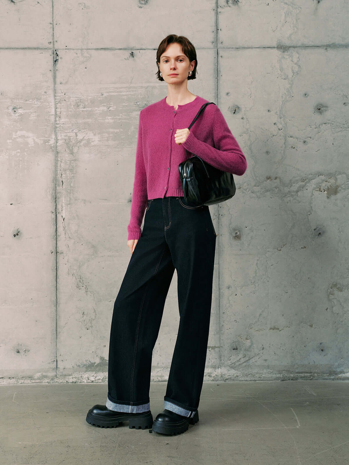 Silk-Cashmere Cardigan styled with black wide-leg pants and a black bag against a concrete wall background.