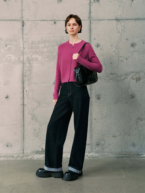 Load image 1 in gallery view. Silk-Cashmere Cardigan styled with black wide-leg pants and a black bag against a concrete wall background.