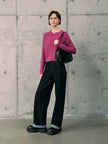 Silk-Cashmere Cardigan styled with black wide-leg pants and a black bag against a concrete wall background.