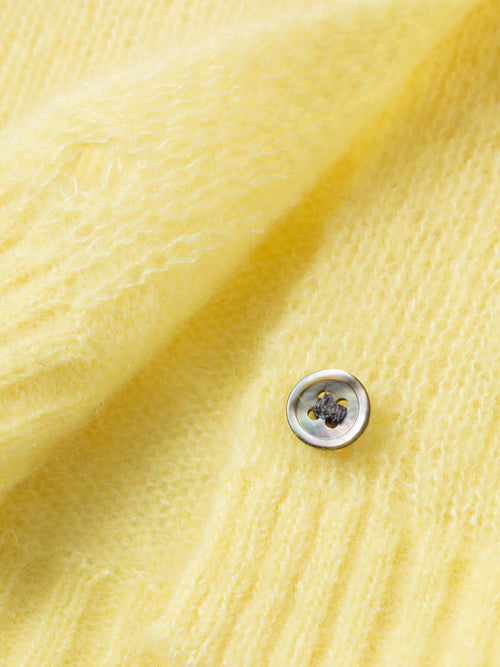 Load image 1 in gallery view. Close-up of a button on a soft yellow Silk-Cashmere Cardigan showcasing its luxurious texture.