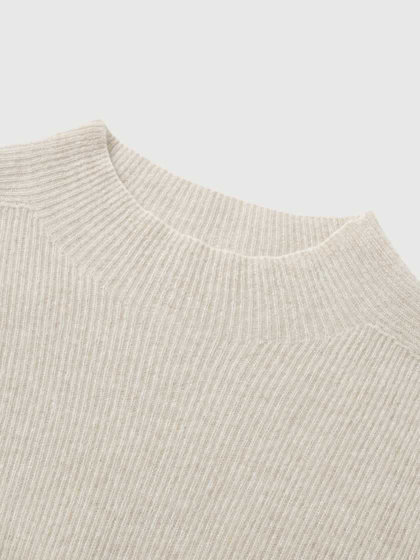 Close-up of a beige knit sweater on a light gray background