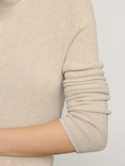 Load image 1 in gallery view. Close-up of a beige sweater sleeve on a plain background