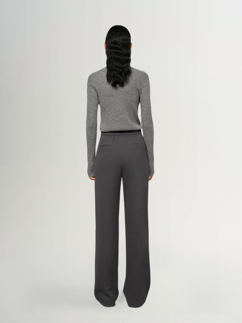 Load image 1 in gallery view. Person wearing a gray sweater and dark gray pants on a white background